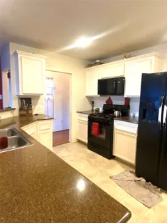 a kitchen with stainless steel appliances a stove a sink and a refrigerator