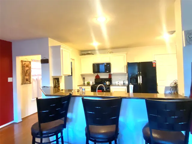 a living room with couches chairs and a large window with wooden floor