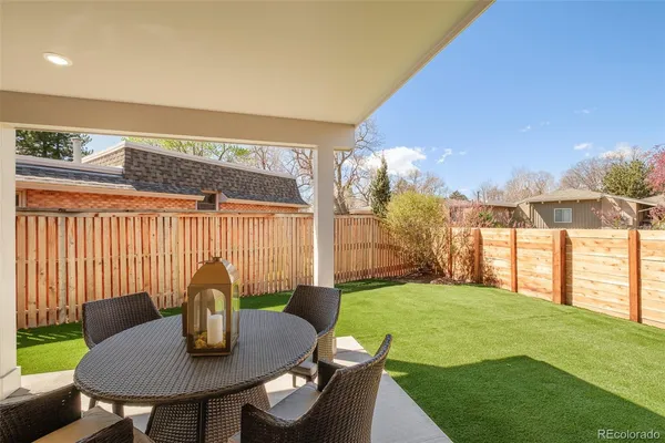 a kitchen with stainless steel appliances a dining table chairs refrigerator and microwave