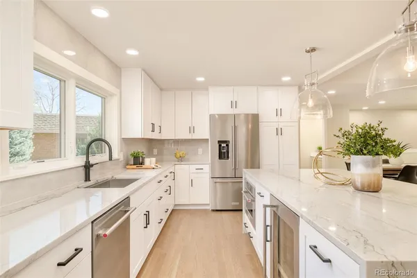 a large room with lots of white furniture and a chandelier