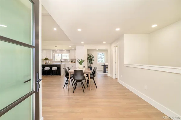 a kitchen with stainless steel appliances kitchen island a table and chairs in it