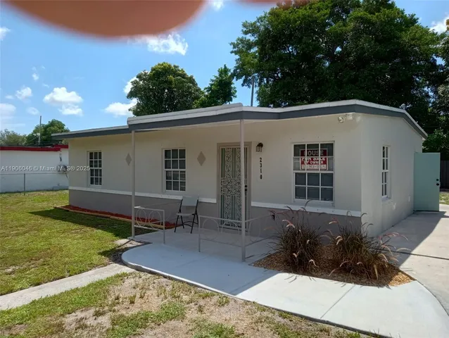 a view of house with backyard and sitting area