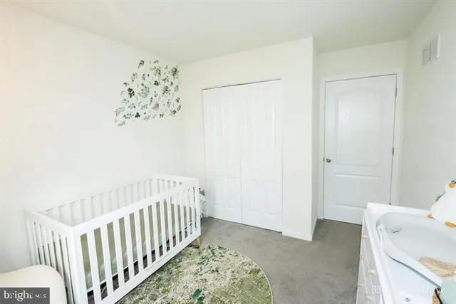 a view of a bedroom with wooden floor and a chandelier fan