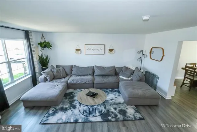 a living room with furniture wooden floor and a large window