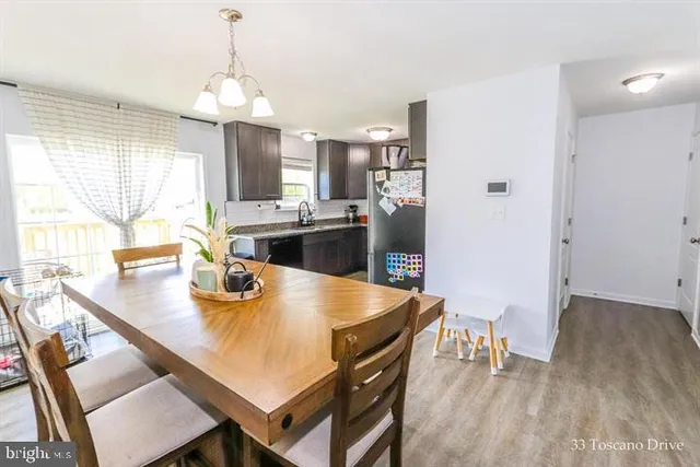 a kitchen with a table chairs and refrigerator