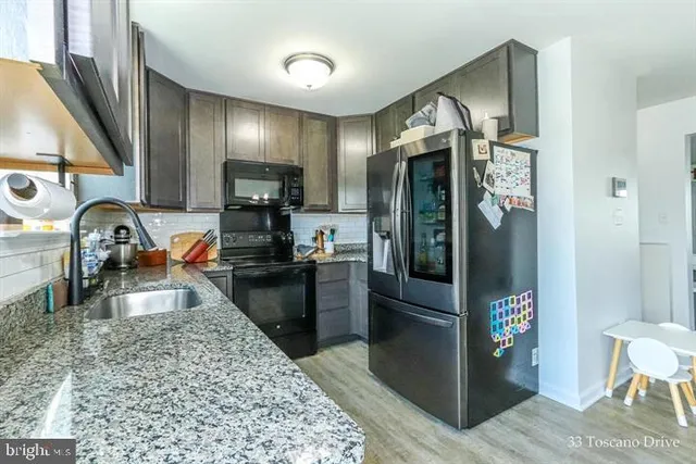 a kitchen with stainless steel appliances granite countertop a refrigerator and a sink