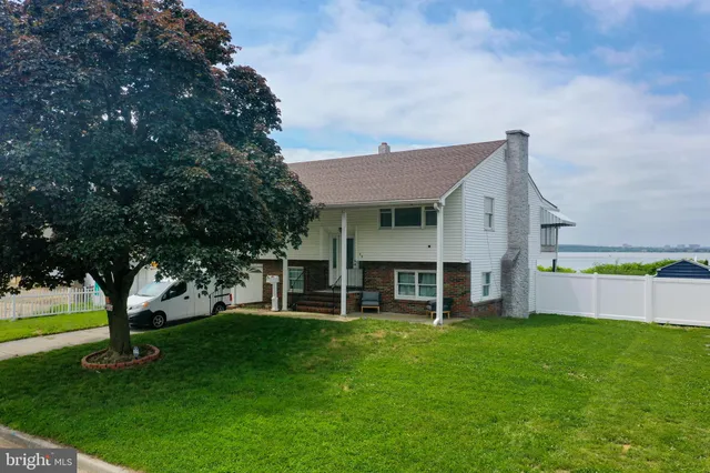 a view of house with a yard and sitting area