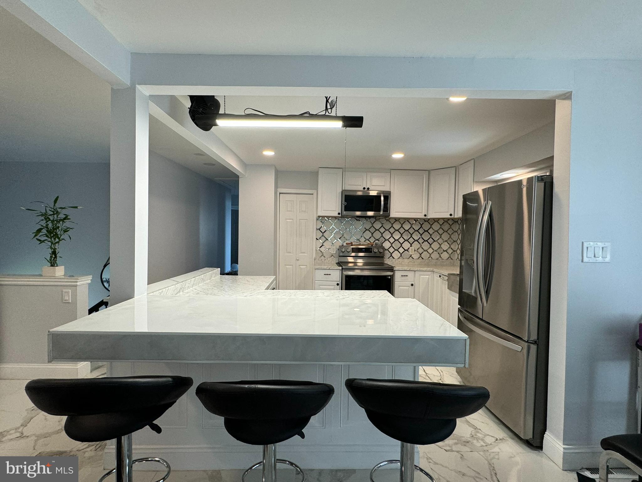 49 Delaware Drive Penns Grove, NJ 08069 - Photo 4 of 26 a kitchen with stainless steel appliances a dining table chairs sink and refrigerator