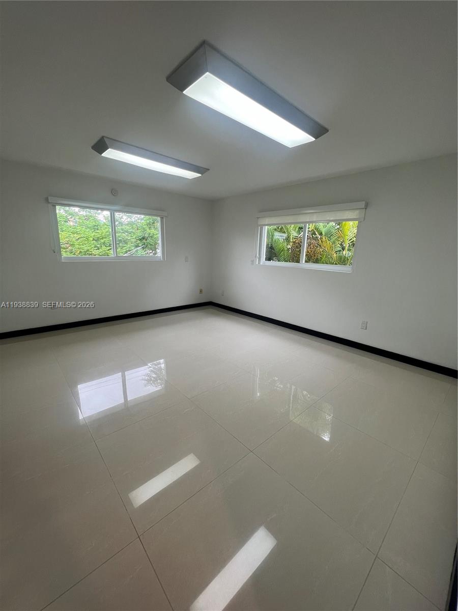 9210 Southwest 73rd Avrd, Unit 9210 Pinecrest, FL 33156 - Photo 6 of 18 an empty room with windows and ceiling fan