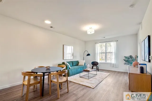 a living room with furniture and a dining table with wooden floor