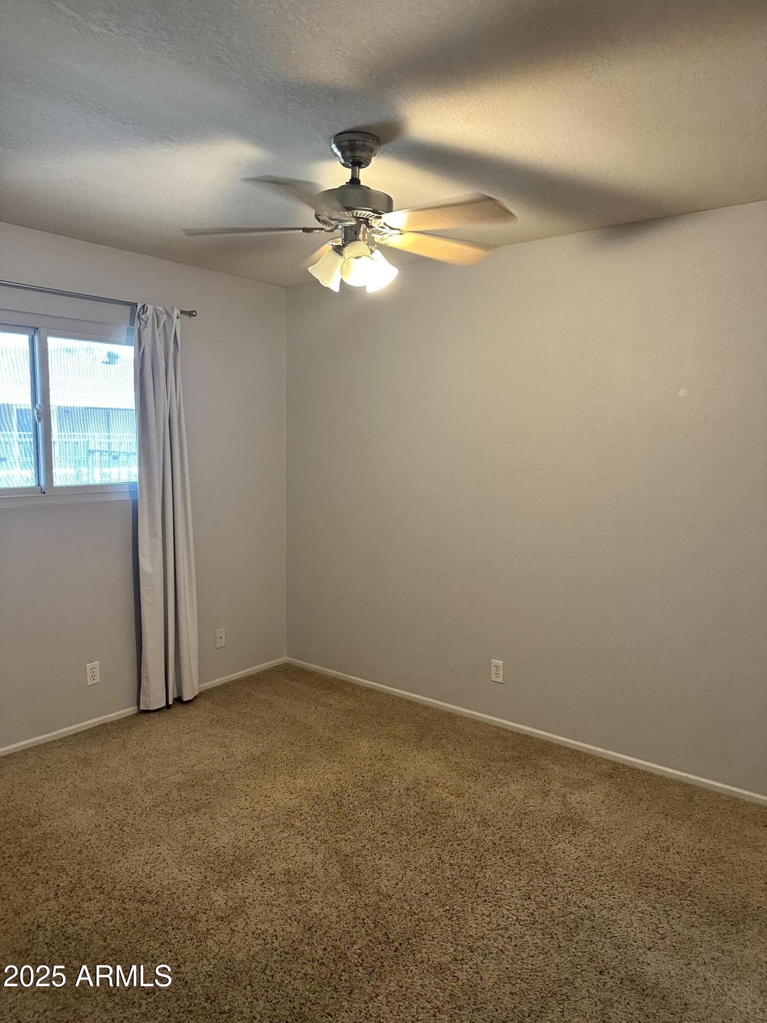 2525 South College Avenue, Unit 2 Tempe, AZ 85282 - Photo 3 of 13 an empty room with windows and fan