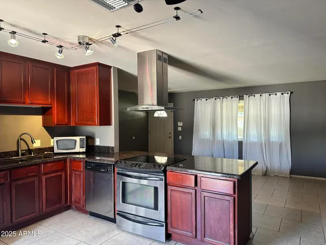 a kitchen with granite countertop a sink stainless steel appliances and cabinets