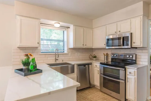 a kitchen with kitchen island granite countertop appliances cabinets and a counter top space