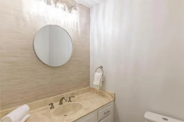 a bathroom with a toilet sink and mirror