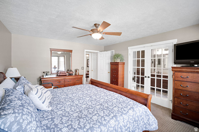 2139 Village Point Way Sandy, UT 84093 - Photo 13 of 35 Primary bedroom with ceiling fan, french doors to primary bath, walk-in closet.
