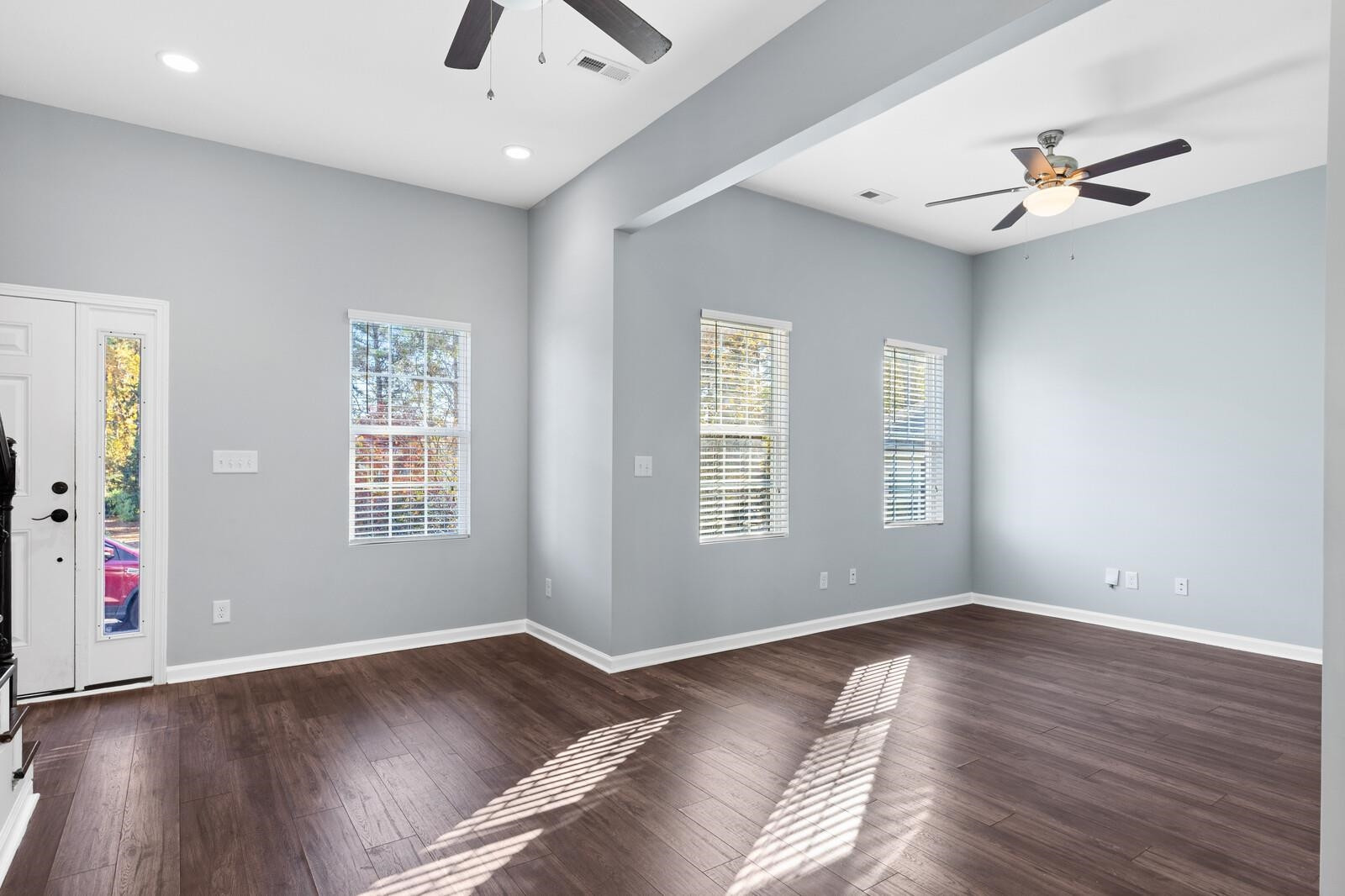 129 Pineland Circle, Unit 100 Raleigh, NC 27606 - Photo 5 of 29 a view of an empty room with wooden floor and a window