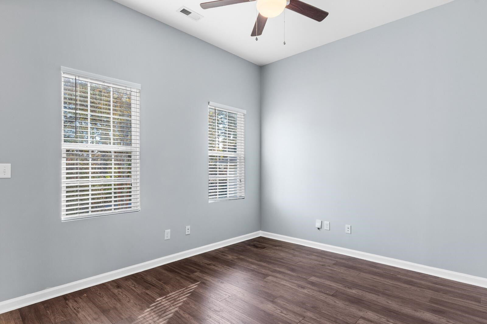 129 Pineland Circle, Unit 100 Raleigh, NC 27606 - Photo 6 of 29 an empty room with wooden floor and windows