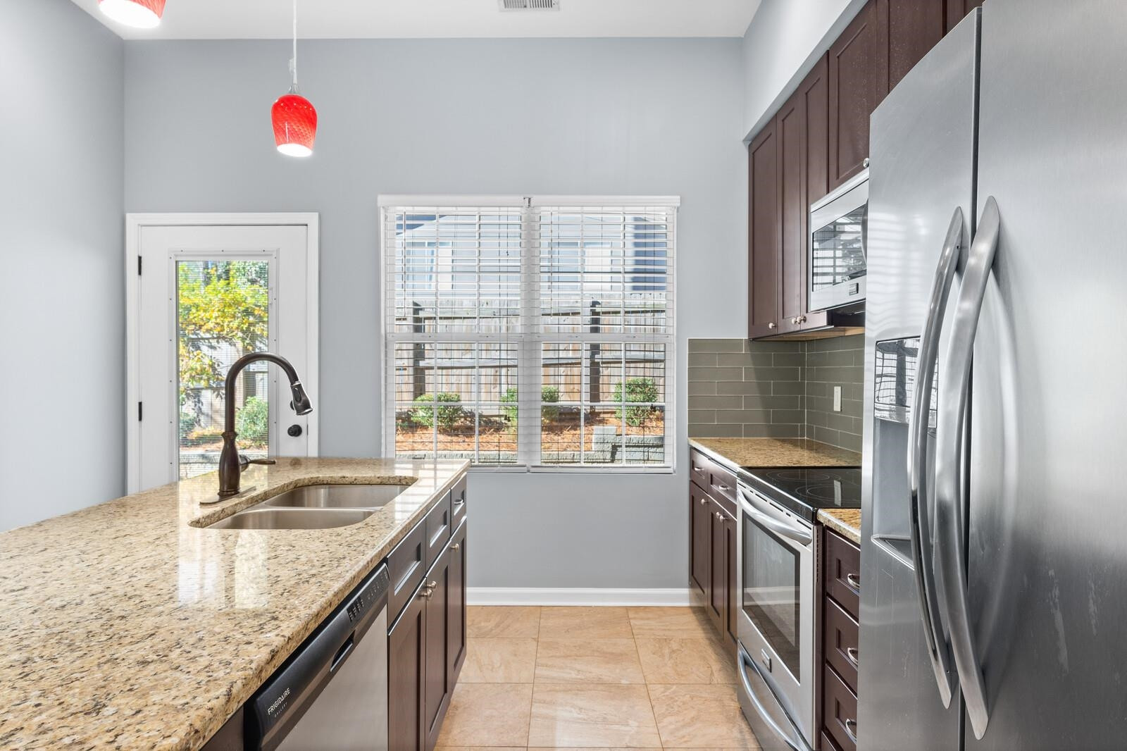 129 Pineland Circle, Unit 100 Raleigh, NC 27606 - Photo 9 of 29 a kitchen with granite countertop a sink stainless steel appliances and a counter top space