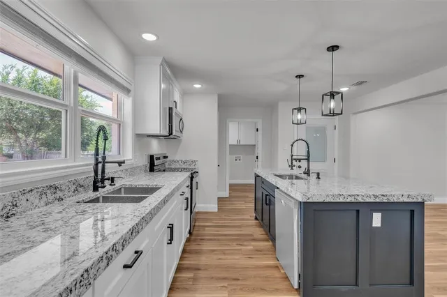 a large kitchen with granite countertop a sink and dishwasher with a large window