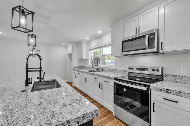 a kitchen with stainless steel appliances granite countertop a stove and a sink