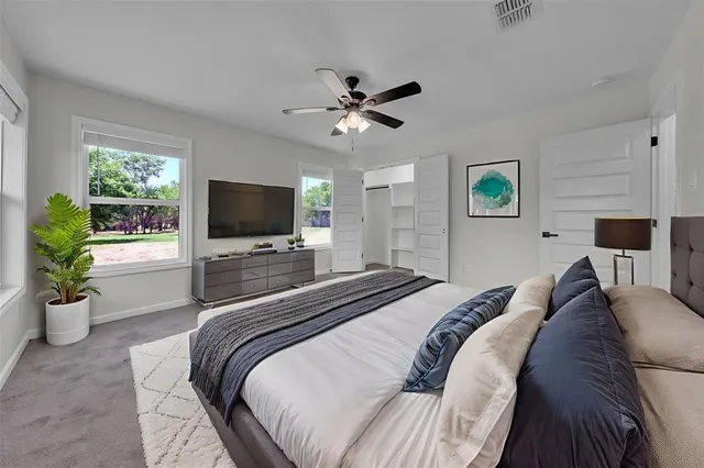 a bedroom with a bed a flat screen tv and a couch