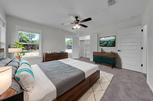 a spacious bedroom with a bed dresser and a window