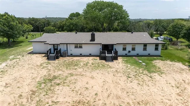 an aerial view of a house with table and chairs under an umbrella