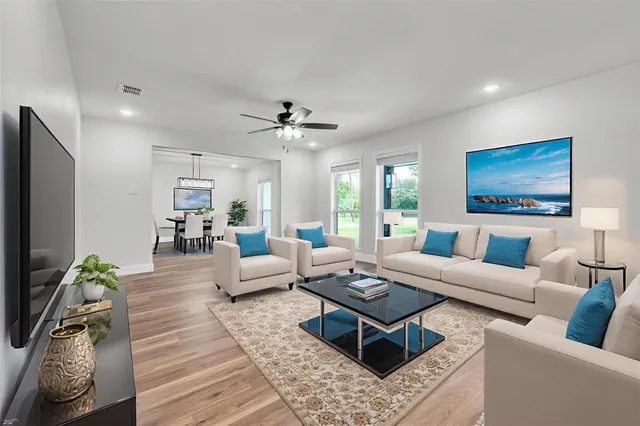 a living room with furniture a large window and a flat screen tv