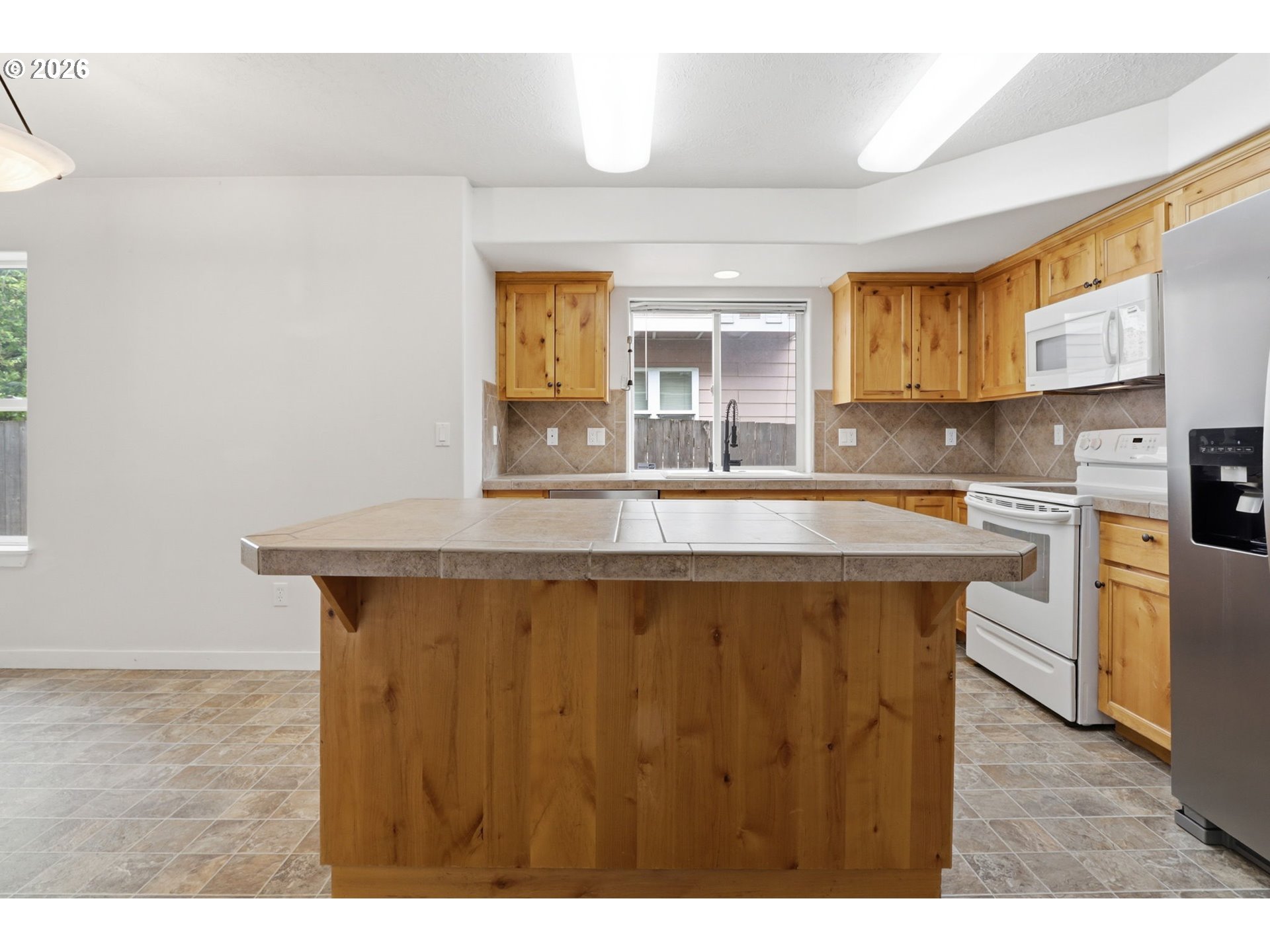 581 Southeast 204th Place Gresham, OR 97030 - Photo 5 of 32 a kitchen with stainless steel appliances granite countertop a sink dishwasher and a black refrigerator with wooden floor