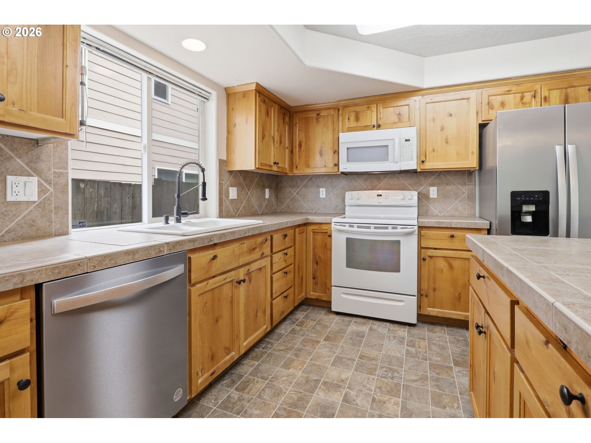 581 Southeast 204th Place Gresham, OR 97030 - Photo 6 of 32 a kitchen with a sink stove and refrigerator