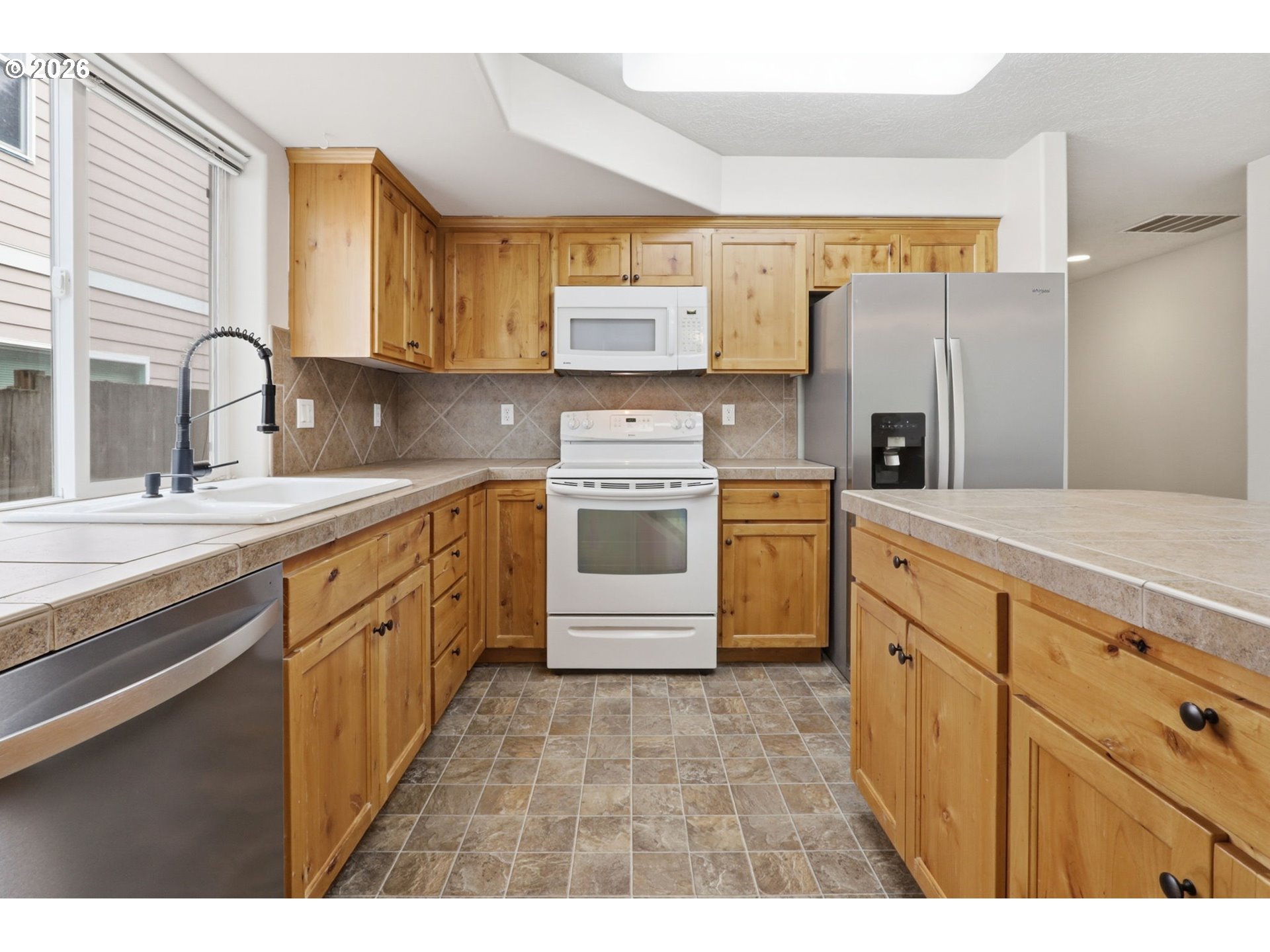 581 Southeast 204th Place Gresham, OR 97030 - Photo 7 of 32 a kitchen with stainless steel appliances a stove sink and refrigerator