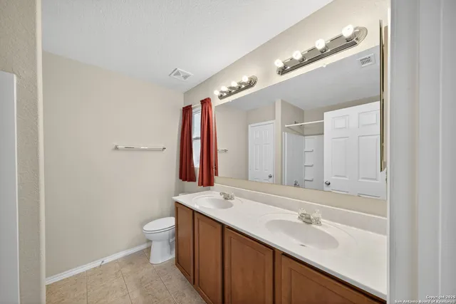 a bathroom with a double vanity sink and a mirror