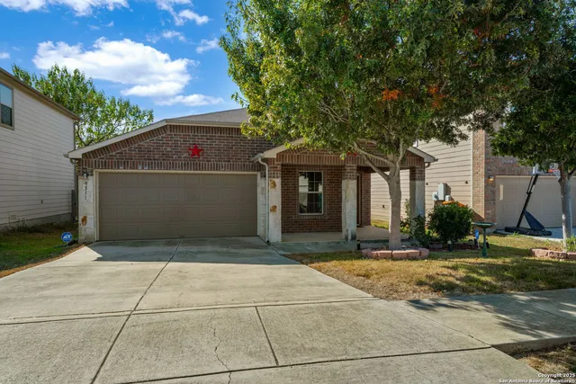 a view of a white house with a large tree