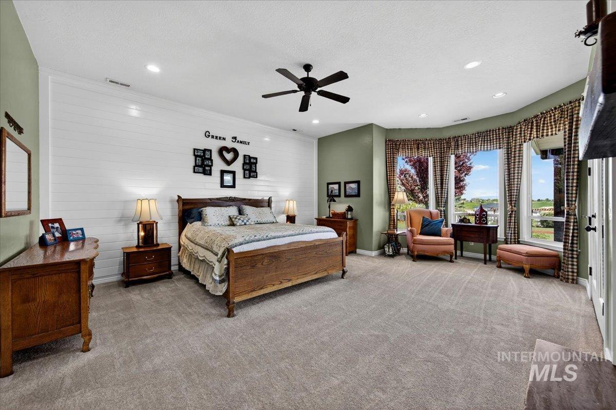 414 East Shafer View Drive Meridian, ID 83642 - Photo 17 of 50 Dreamy Main lvl 22x16 Primary Bdrm - Wake up to a morning VIEW of Bogus Basin & sweeping view of the Boise Front! Tongue & Groove Painted accent wall, ceiling fan, Plush carpet, bayed seating area, gas log fireplace.