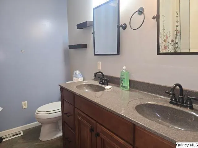 a bathroom with a toilet a sink and mirror