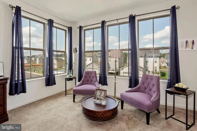 a living room with furniture and a floor to ceiling window