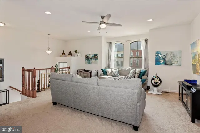 a living room with furniture a ceiling fan and a window