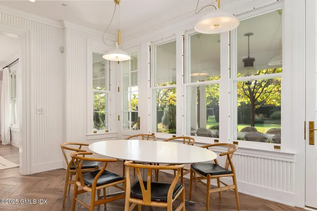a dining room with furniture a chandelier and wooden floor