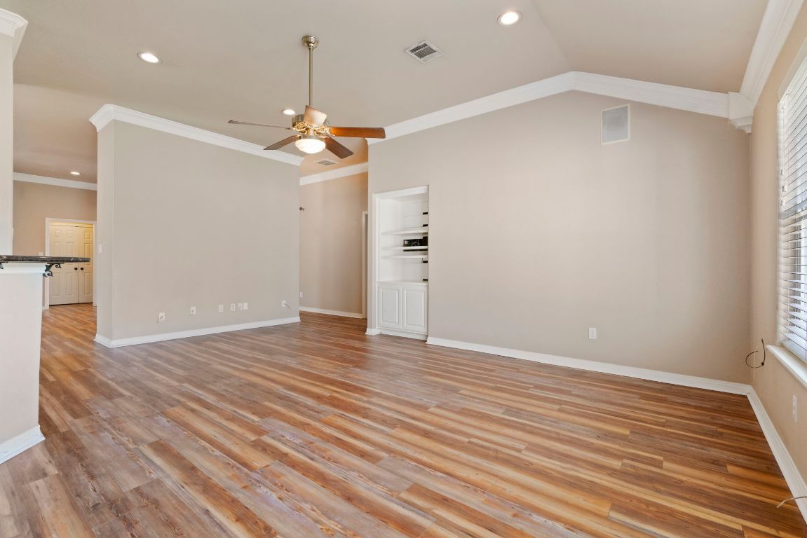 1237 Ridge Harbor Drive Spicewood, TX 78669 - Photo 16 of 40 an empty room with wooden floor ceiling fan and window