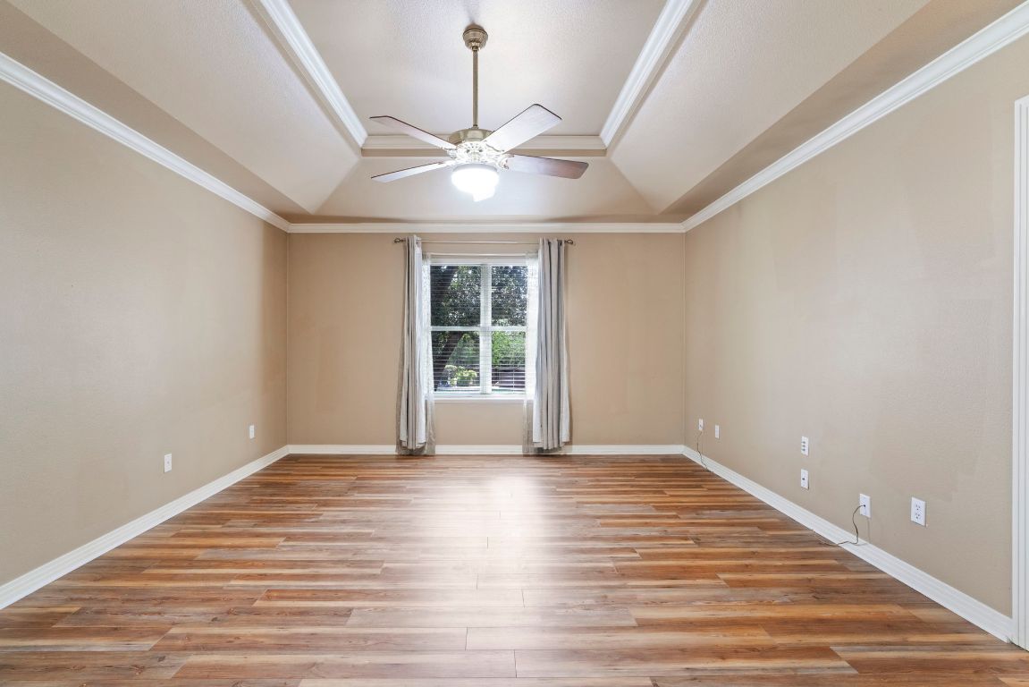 1237 Ridge Harbor Drive Spicewood, TX 78669 - Photo 17 of 40 a view of an empty room with wooden floor and a window