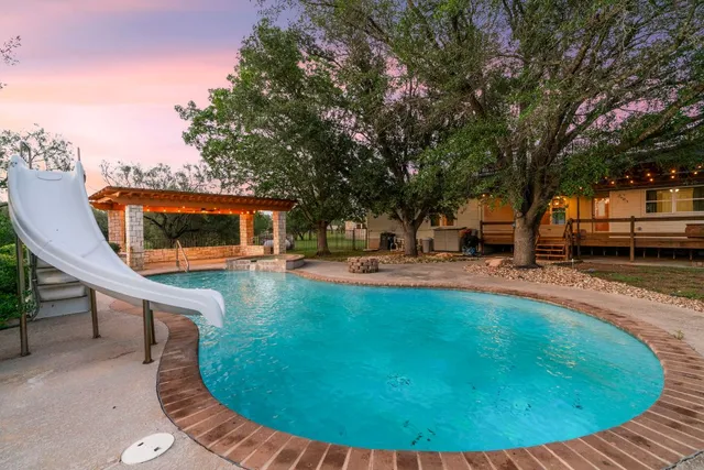 a swimming pool with outdoor seating and yard