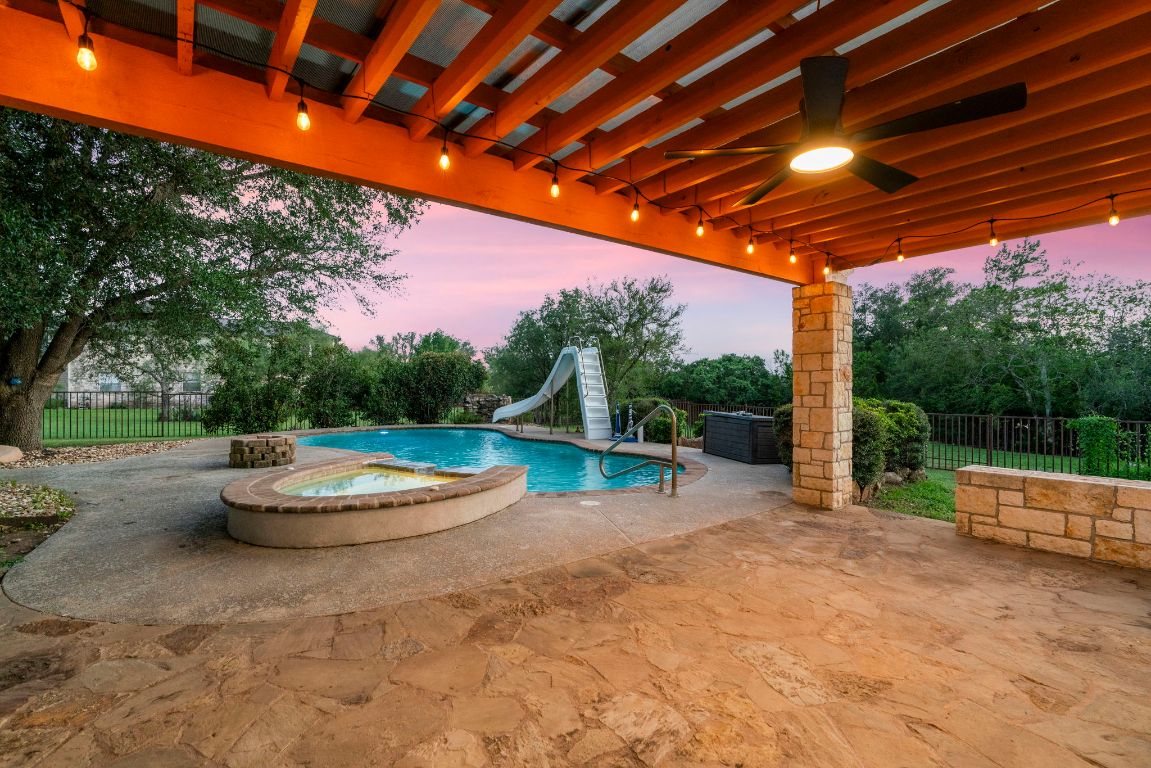 1237 Ridge Harbor Drive Spicewood, TX 78669 - Photo 34 of 40 a backyard of a house with fountain table and chairs