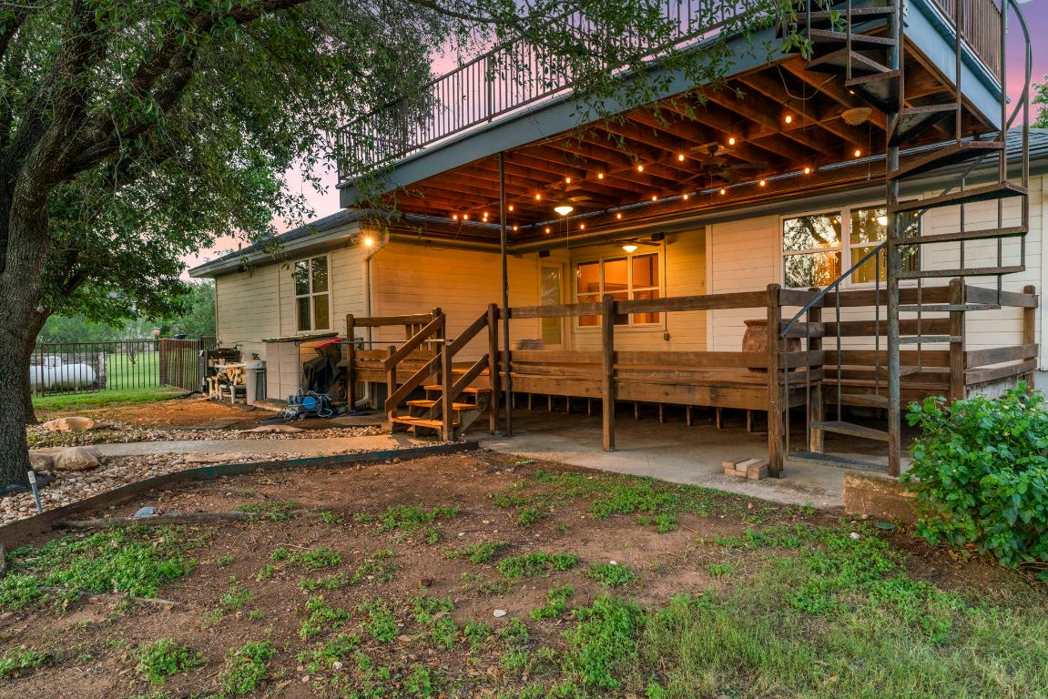 1237 Ridge Harbor Drive Spicewood, TX 78669 - Photo 35 of 40 a view of a backyard with lawn chairs and a barbeque