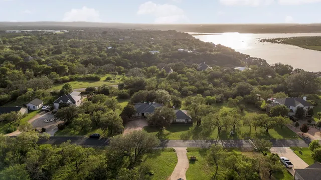 an aerial view of residential houses with outdoor space and trees