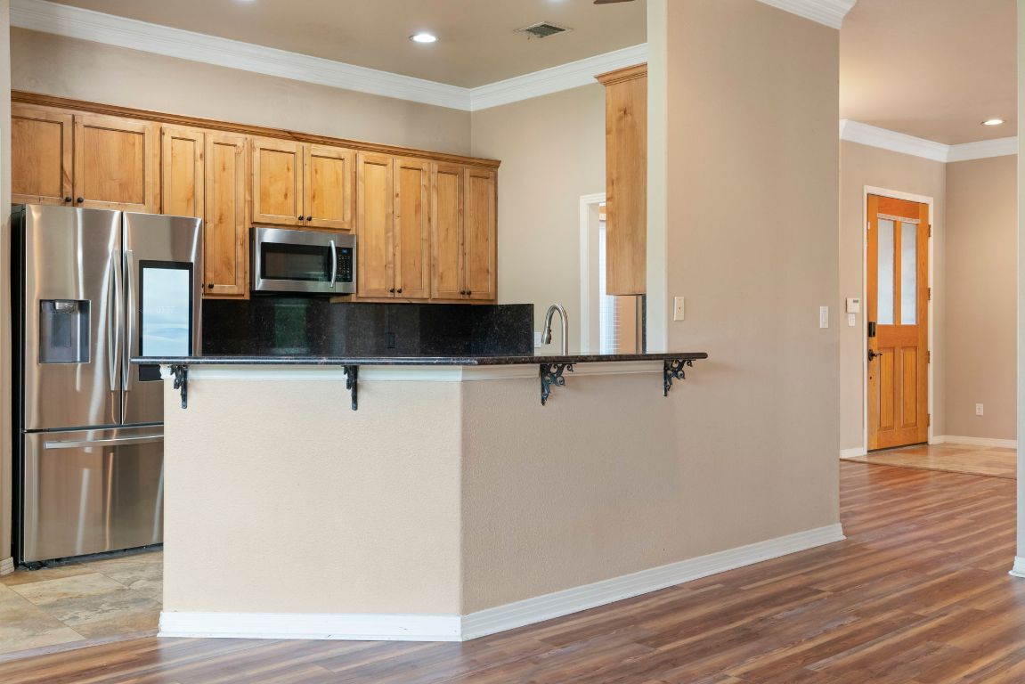 1237 Ridge Harbor Drive Spicewood, TX 78669 - Photo 4 of 40 a kitchen with stainless steel appliances a refrigerator and wooden floors