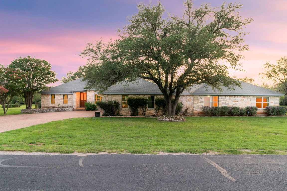 1237 Ridge Harbor Drive Spicewood, TX 78669 - Photo 7 of 40 a front view of a house with a garden and trees