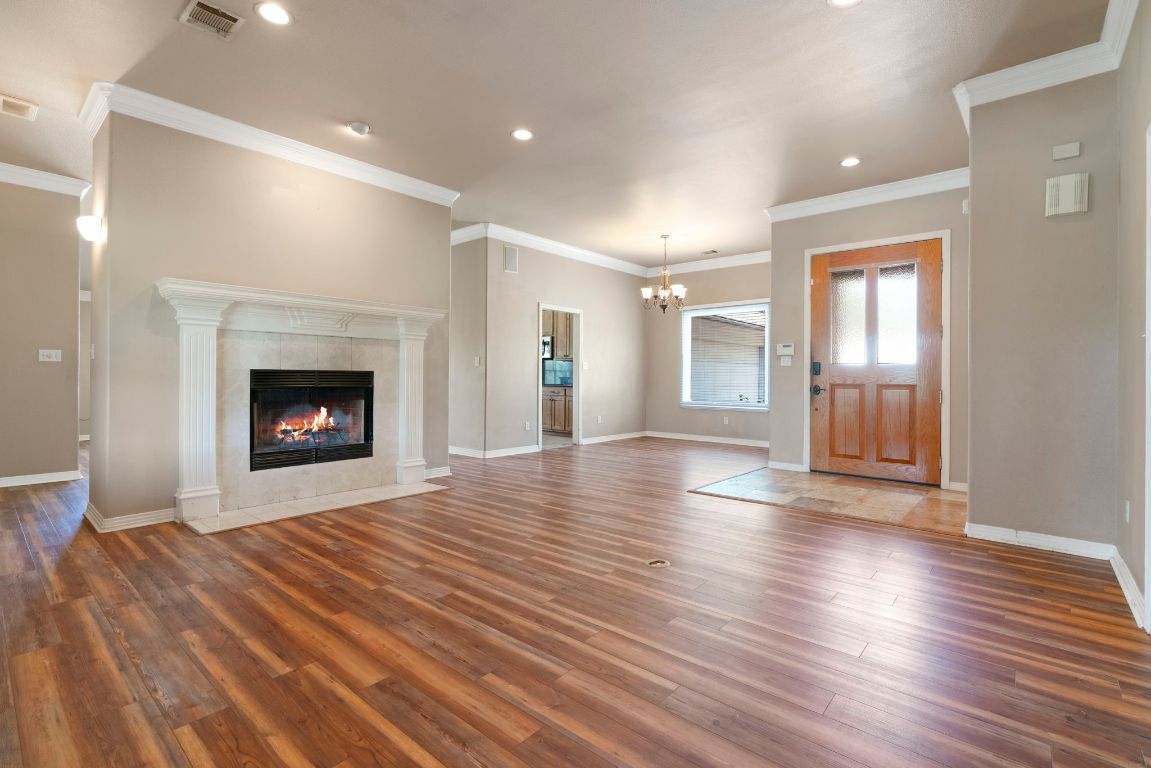1237 Ridge Harbor Drive Spicewood, TX 78669 - Photo 9 of 40 a view of an empty room with wooden floor fireplace and a window