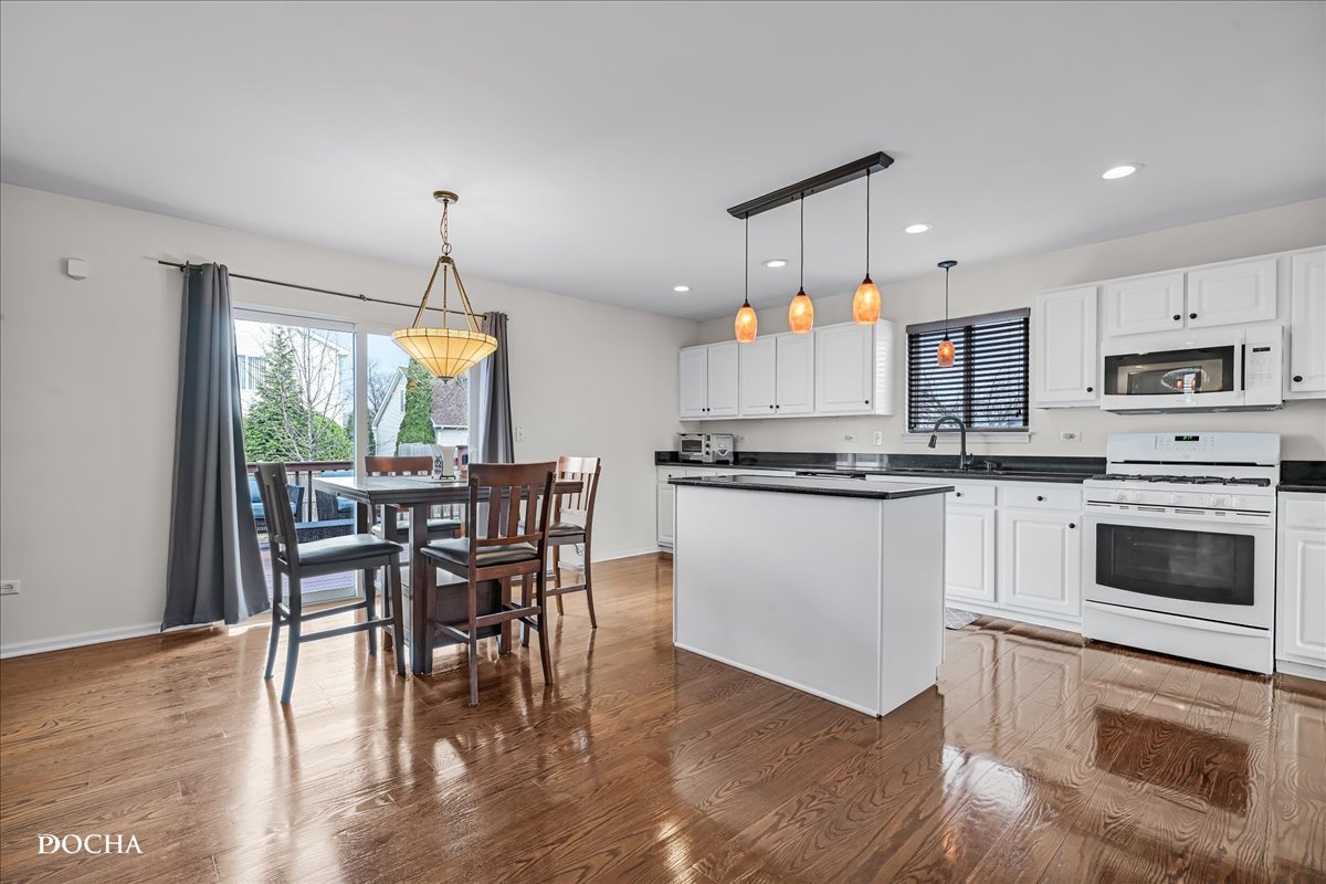 4301 Anthony Lane Plainfield, IL 60586 - Photo 6 of 31 a kitchen with stainless steel appliances a dining table chairs stove and microwave