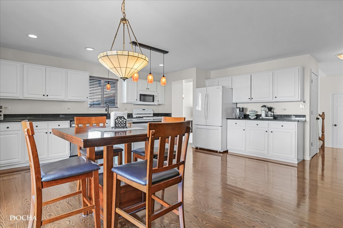 4301 Anthony Lane Plainfield, IL 60586 - Photo 9 of 31 a kitchen with stainless steel appliances granite countertop a stove top oven a dining table and chairs