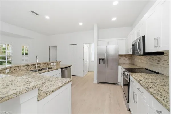 a kitchen with stainless steel appliances granite countertop a sink stove and refrigerator